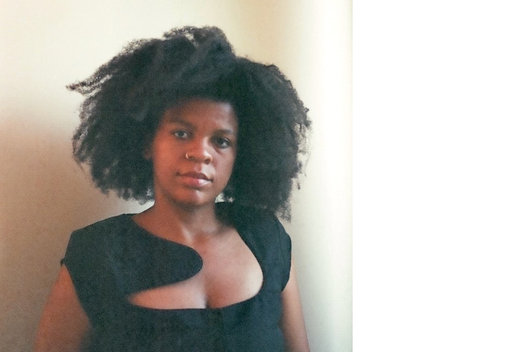 Portrait of Tadiwa Madenga, woman with black hair and dress