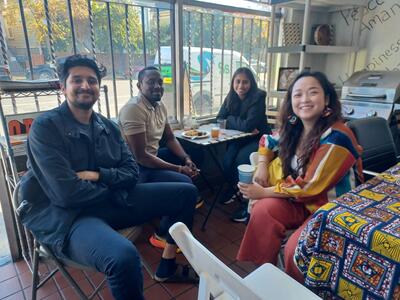 Four seated students enjoying food and coversation.