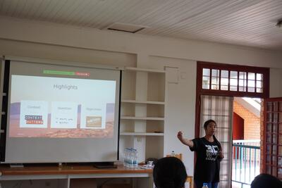 Photo of Veronarindra Ramananjato leading a workshop by a powerpoint.